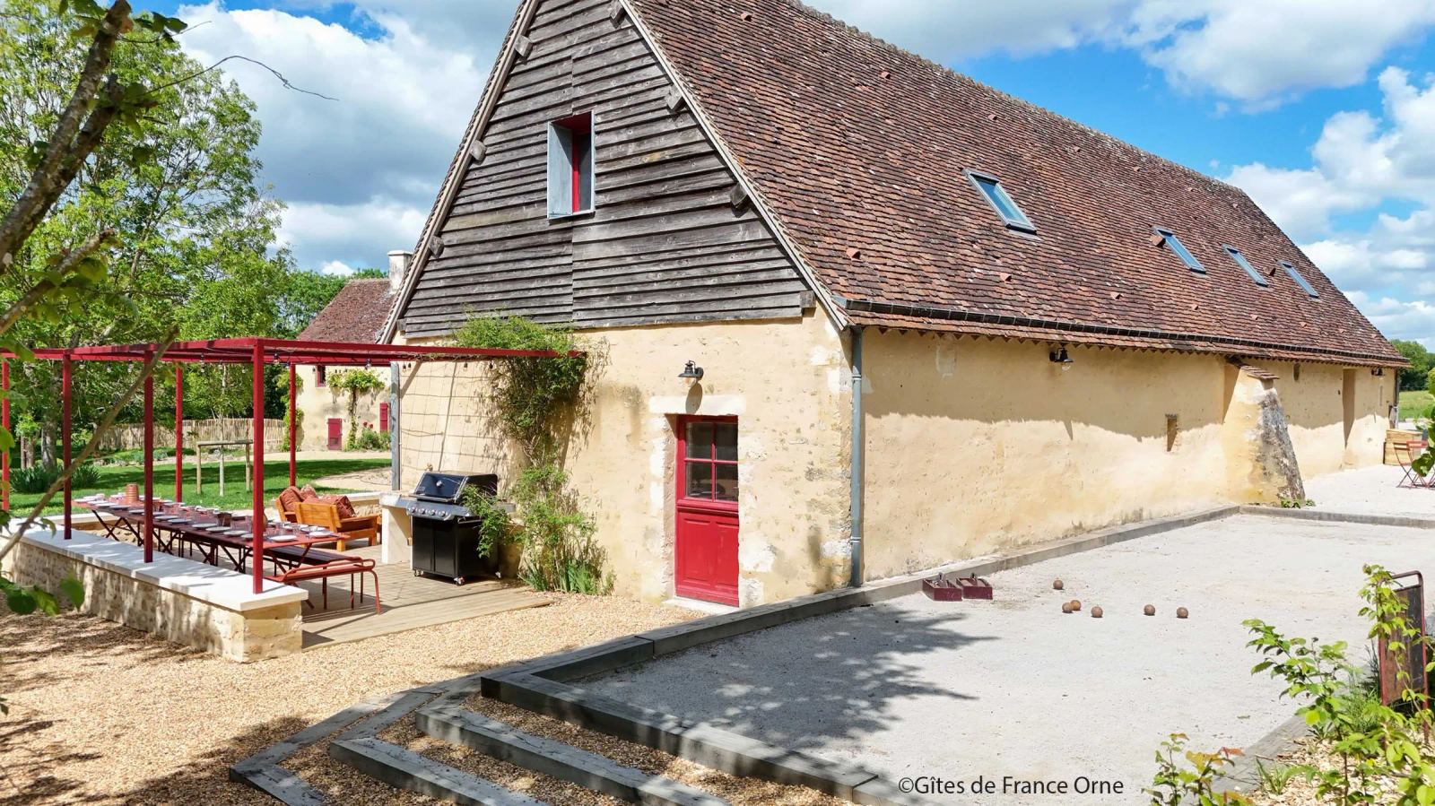 Terrain de pétanque devant la grange en pierre aux portes rouges — Maison Oiserie